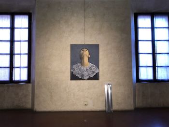 Low angle view of female statue against window in building