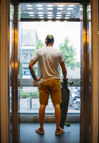 Boy in elevator with skateboard