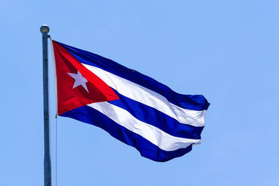 Low angle view of flag against clear blue sky