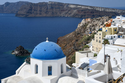 Panoramic view of sea and buildings against blue sky