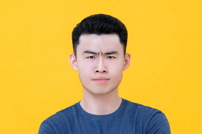 Portrait of handsome man against yellow background