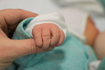 Low section of baby holding hands