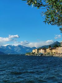 Buildings at waterfront against cloudy sky