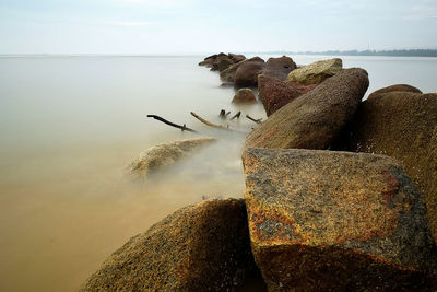 Rocks on beach against sky