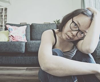 Portrait of woman sitting on sofa at home