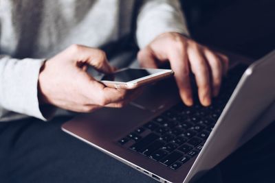 Midsection of man using mobile phone