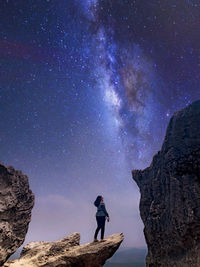 Rear view of man standing against sky at night