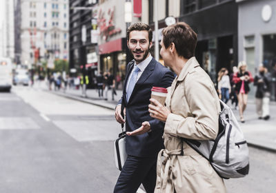 Usa, new york city, businessman and woman walking in manhattan