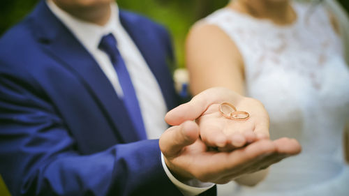 Close-up of couple holding rings