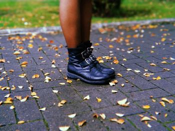 Low section of person legs on autumn leaves on street