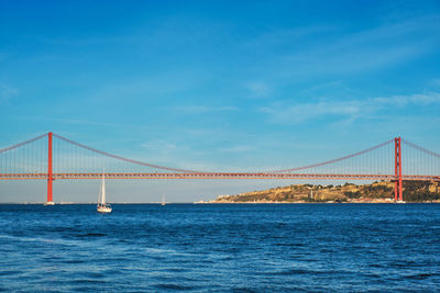 Suspension bridge over sea against sky