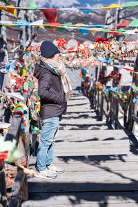 Side view of woman standing on footbridge