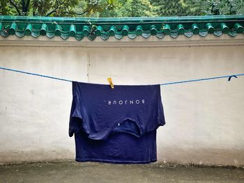 Clothes drying on railing against wall