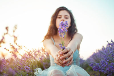 A beautiful young girl against the sunset and a beautiful sky in a lavender field. 