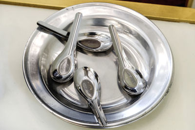 Close-up high angle view of spoons in silver plate on table