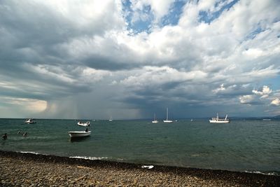 Boats moored at harbor against sky