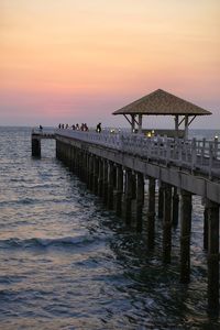 Pier over sea against sky during sunset