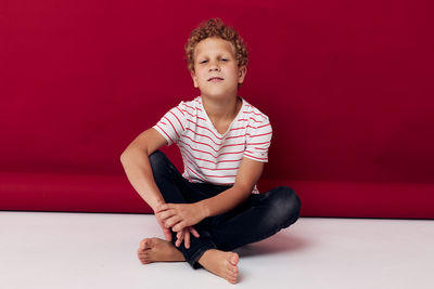 Portrait of boy sitting on hardwood floor