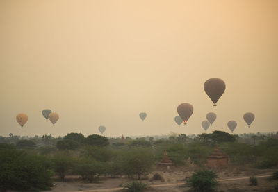 Hot air balloons flying against sky during sunset