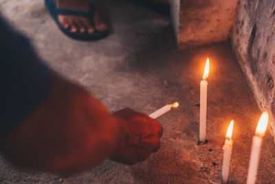 High angle view of hand holding lit candles