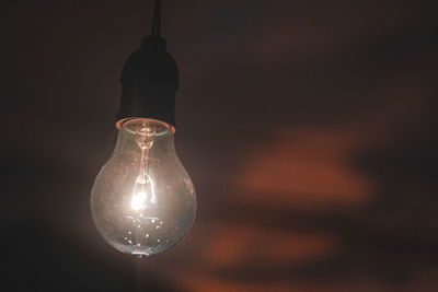 Close-up of illuminated light bulb in darkroom