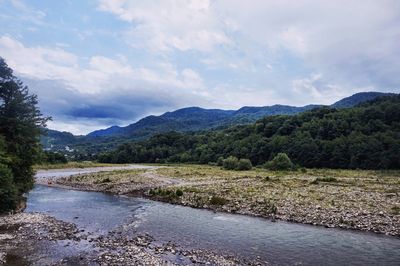 Scenic view of lake against cloudy sky