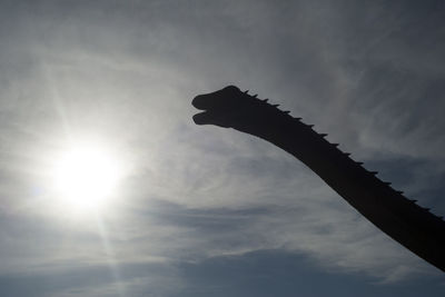 Low angle view of silhouette cross against sky on sunny day