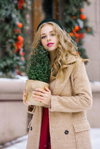 An attractive happy girl walks around the christmas winter city, holding a toy in her hands