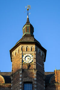 Low angle view of clock tower against clear blue sky