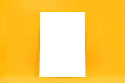 Close-up of yellow paper against orange background