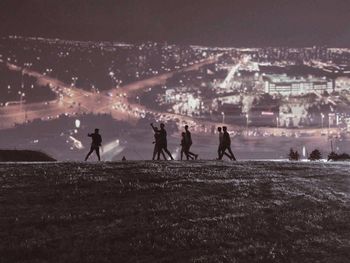 Silhouette people in city at night