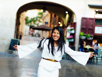 Portrait of smiling young woman in city