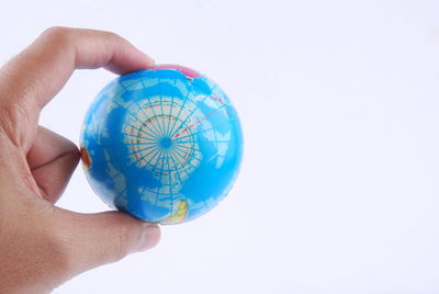 Close-up of hand holding bubble against white background