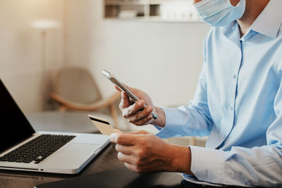 Midsection of man using mobile phone