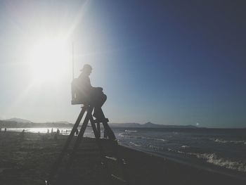 Man photographing at beach against clear sky