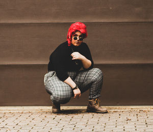 Portrait of woman standing against wall