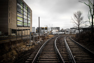 Railroad tracks in city against sky