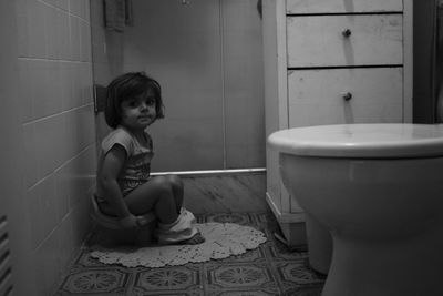 Portrait of girl sitting in bathroom