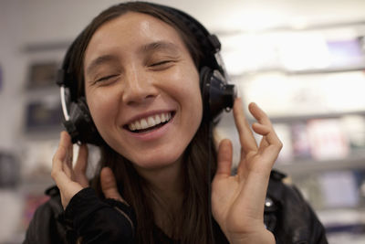 Young woman listening to music in a record store