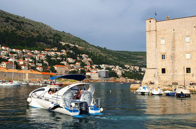 Boats in river with buildings in background