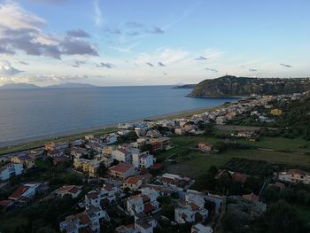 High angle view of townscape by sea against sky