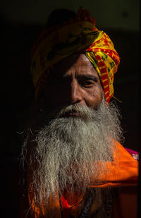 Close-up portrait of senior man standing in darkroom