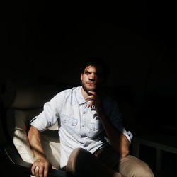 Sunlight falling on thoughtful man on chair