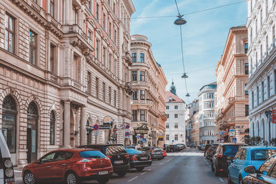 Traffic on road amidst buildings in city