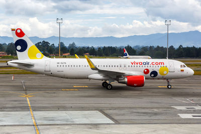 Airplane on airport runway against sky