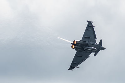 Low angle view of airplane flying against sky