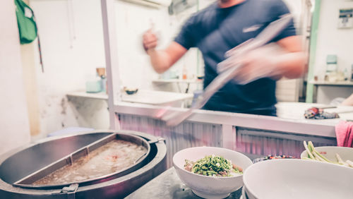 Midsection of man preparing food in kitchen