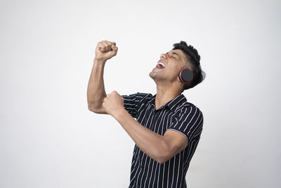 Young man looking away against white background