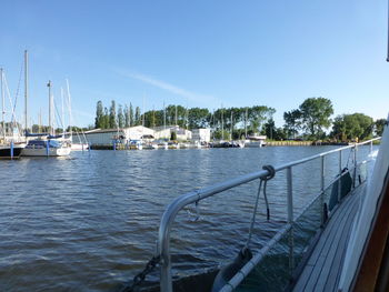 Sailboats moored on sea against clear sky