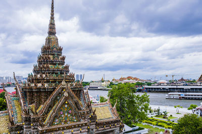 Temple by building against sky